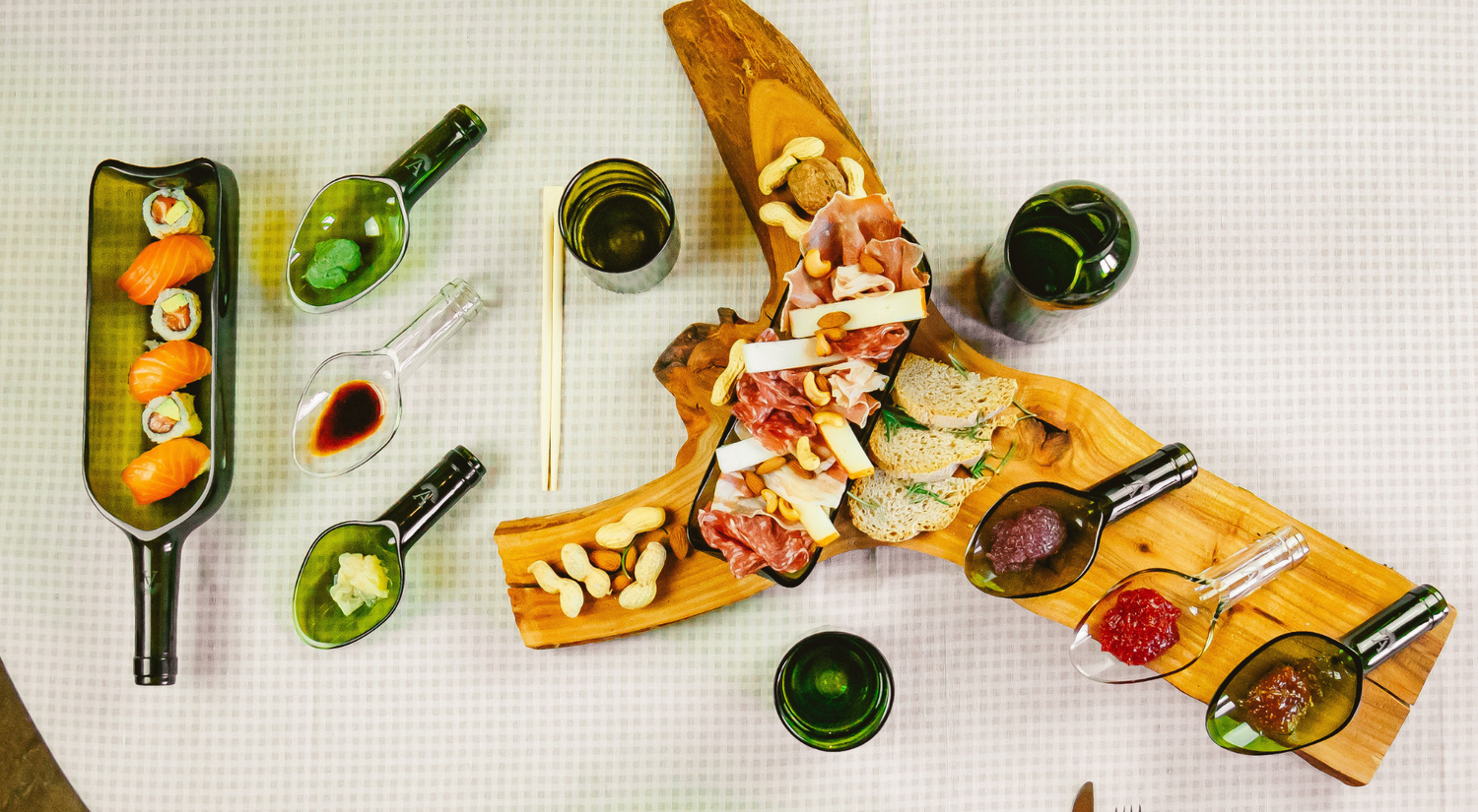 Tavola apparecchiata con oggetti e stoviglie in vetro riciclato amarzo ibandito con prodotti tipici toscani